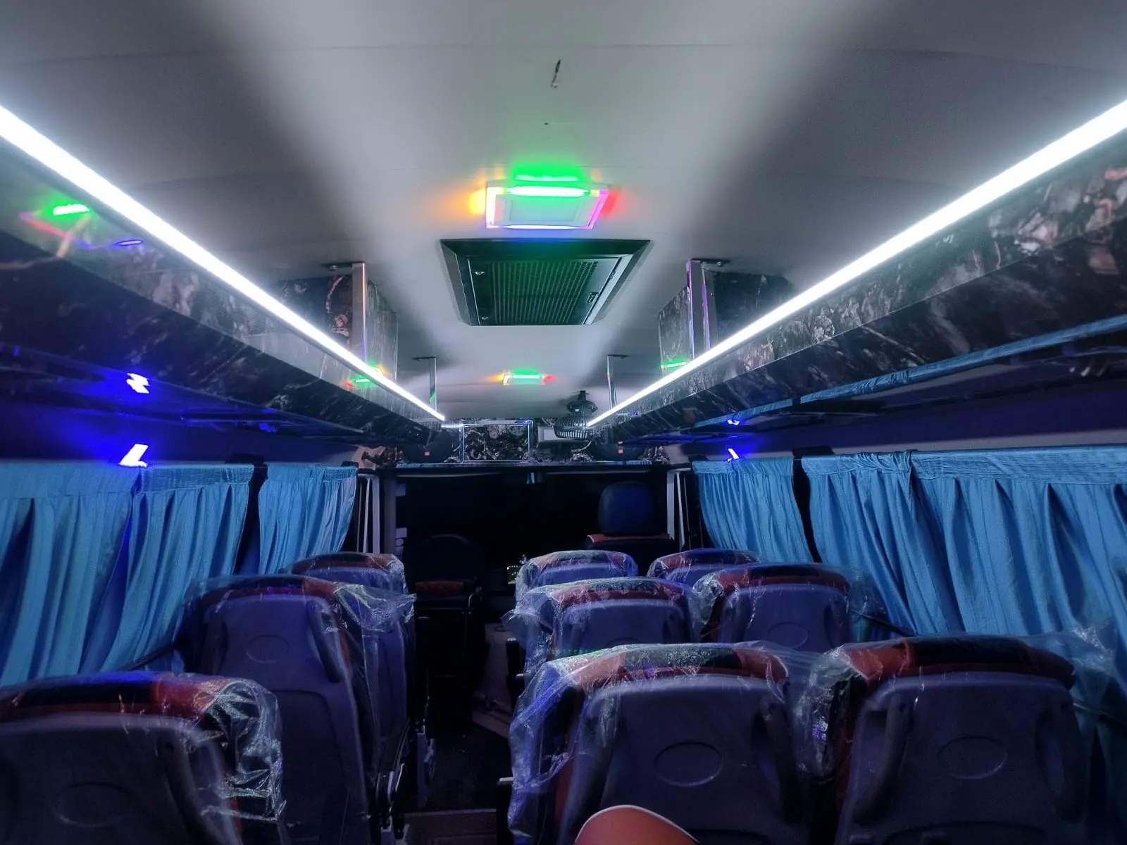 17-seater Tempo Traveller AC bus front view at night with headlights on
